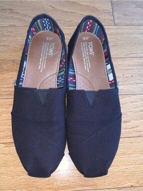 Toms Women’s Black Classic Canvas Slip-Ons, Multicolor Striped Lining, Size 8
